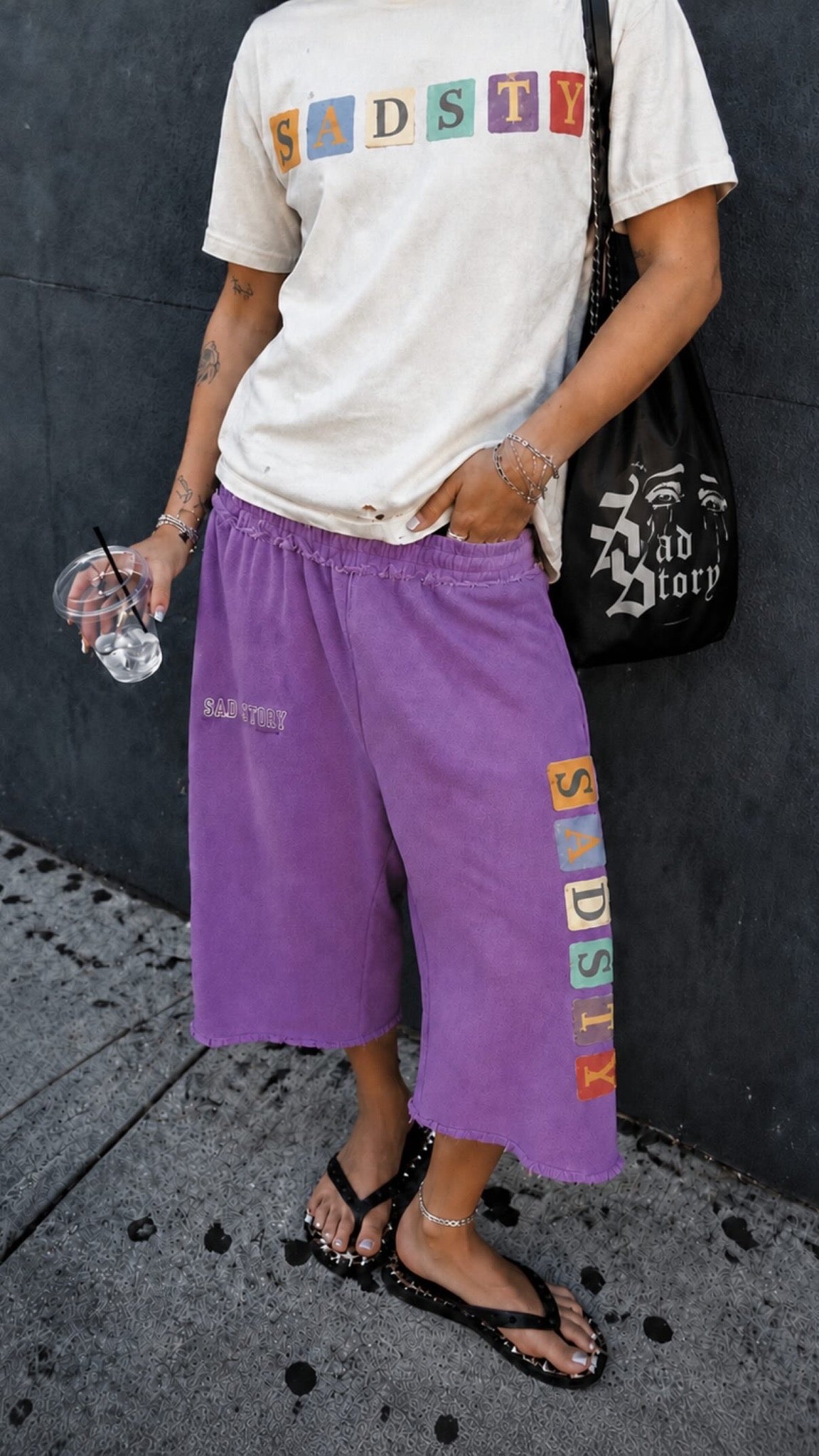 SadStory graphic tee and purple shorts; shorts sold individually